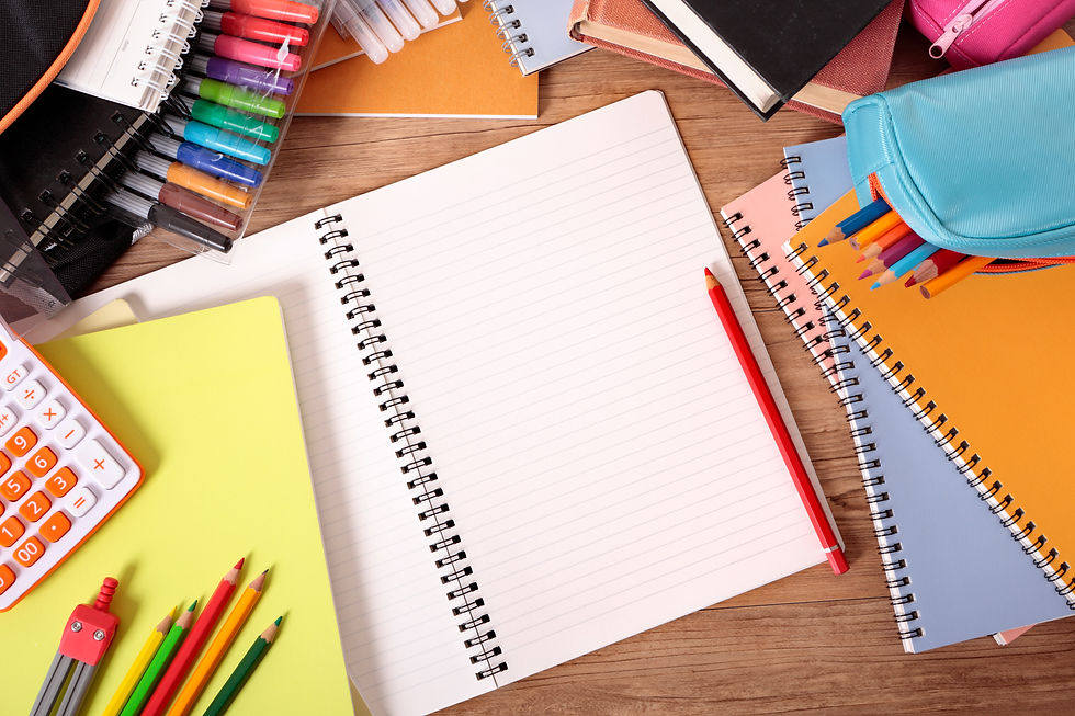 An overhead view of stationery items such as notebooks, pencil crayons, markers, calculator, books, and pencil cases.