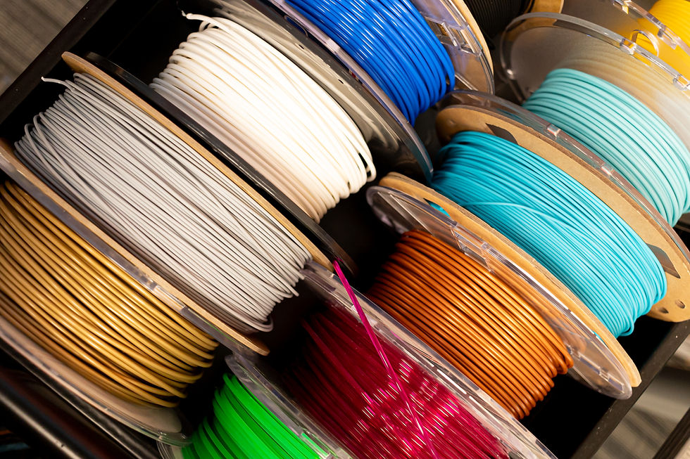 Spools of colourful 3D printing filament seen from above.