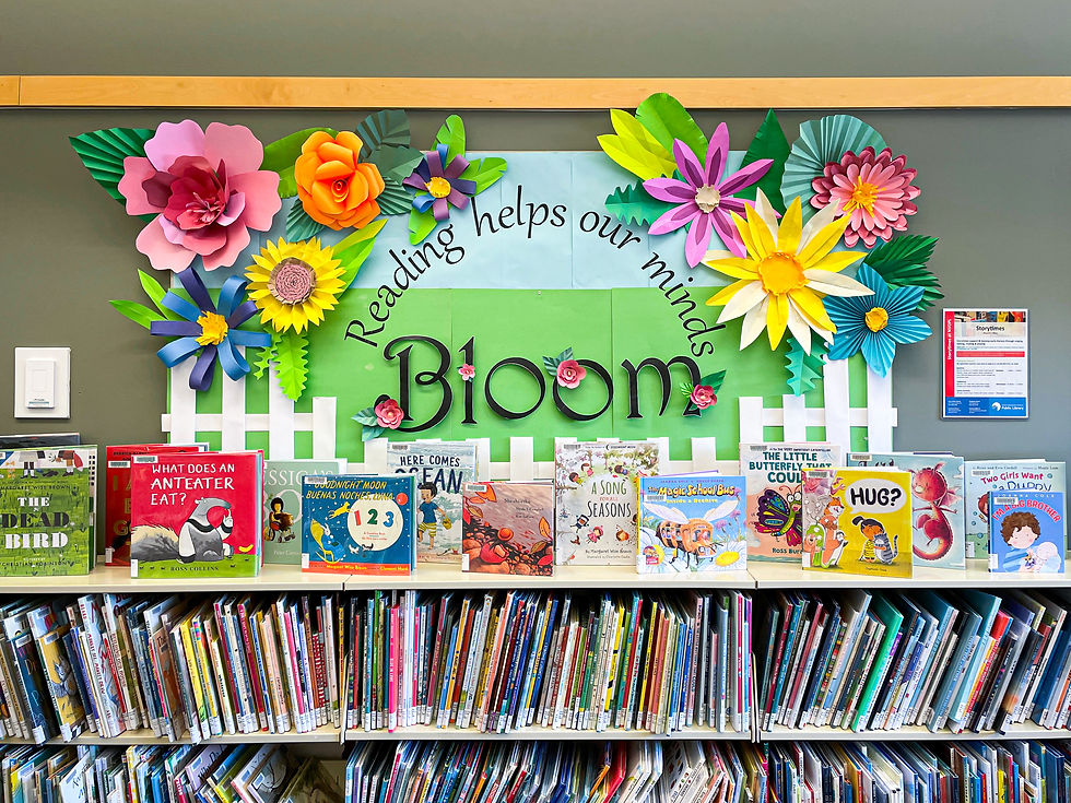 Colourful children's books sit on a shelf with their spines facing out.