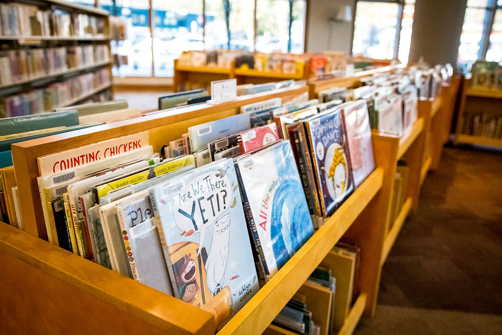 A low wooden shelf filled with childrens books.